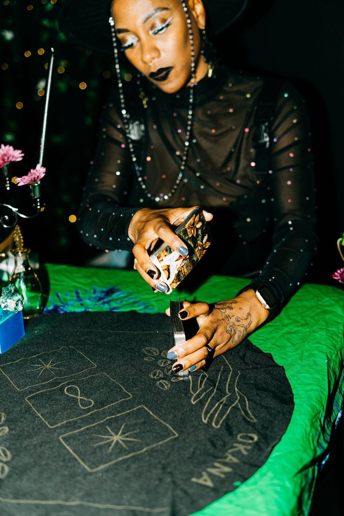 A Black woman shuffles tarot cards