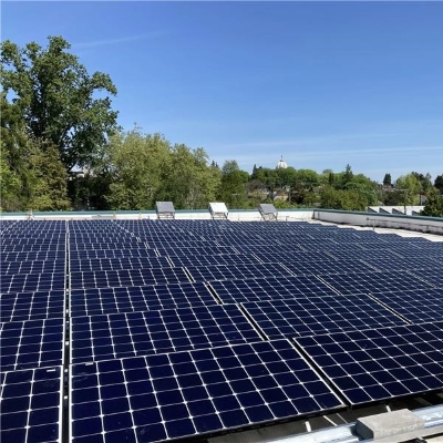 Workers stand next to solar panels on the roof of Miller Community Center.