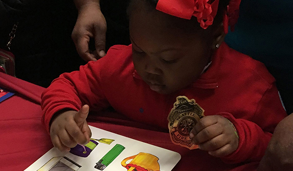 Child reading a fire safety pamphlet