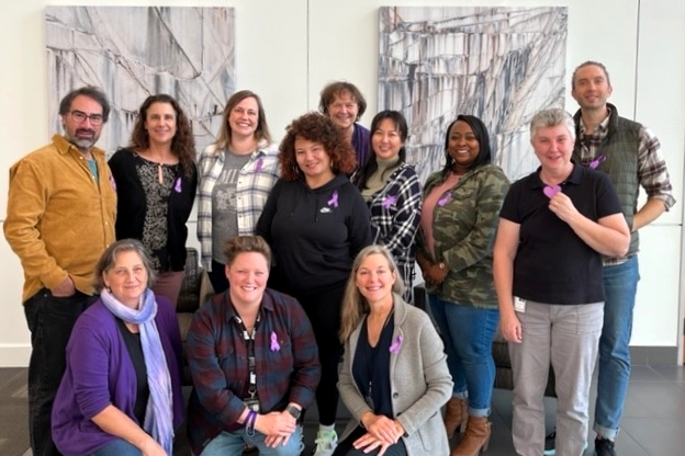 Photo of smiling HSD employees from ADS Contracts Unit recognizing Purple Thursday in October 2022
