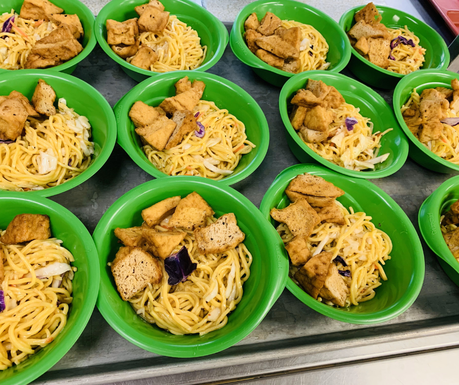 A tray of tofu noodle salad in green bowls