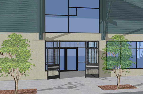 Main entrance of  the community center with double glass doors and metal security gates, set in a beige wall with large geometric window above. Two small trees are planted in rectangular sidewalk cutouts on either side of the doorway