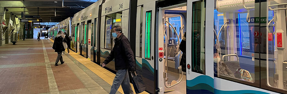 A person exiting a Sound Transit light rail train at a station.