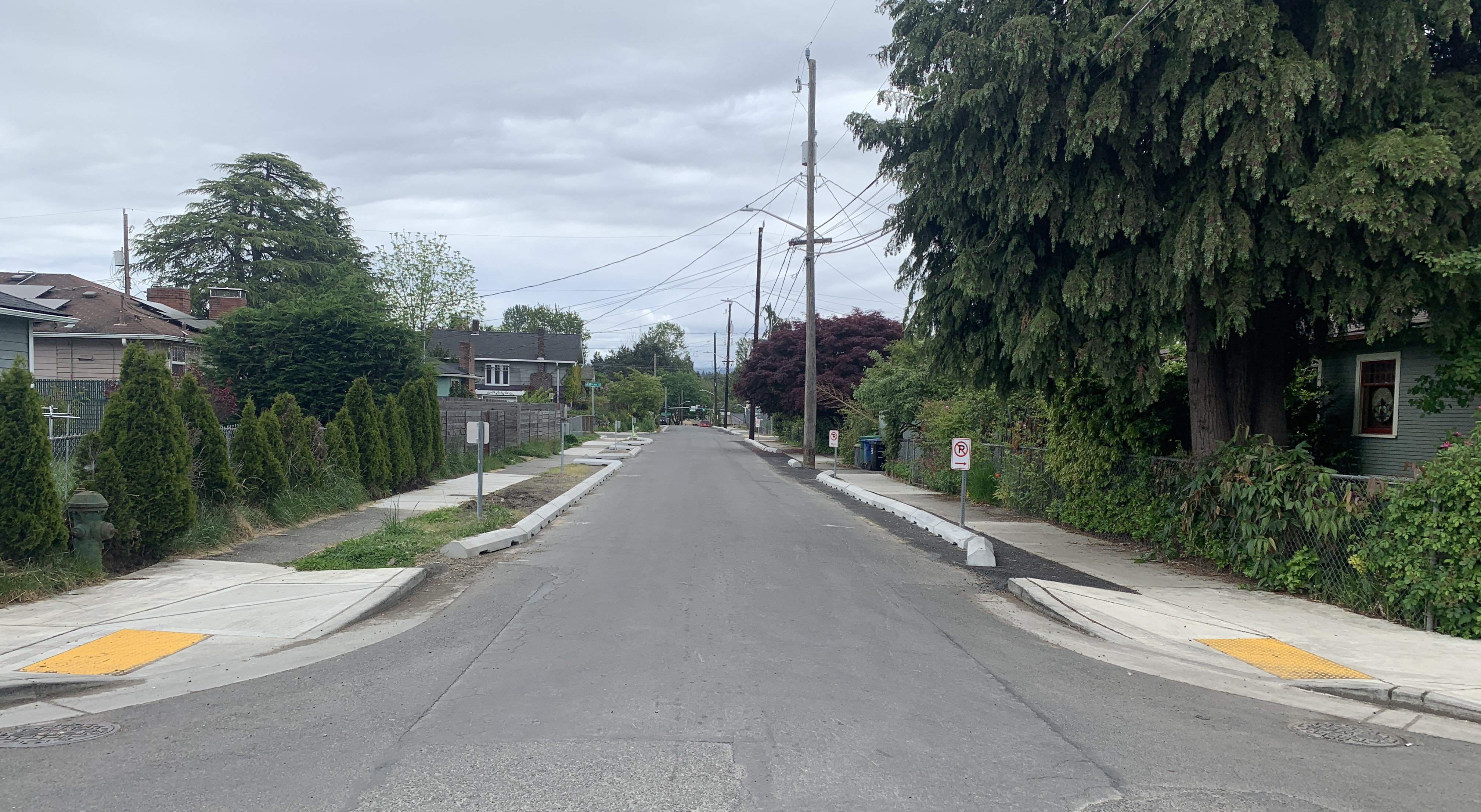 The photo above shows newly reconstructed sidewalks, curb ramps with tactile warning strips, and new planting strip along S Rose St between 48th Ave S and 50th Ave S (June 2025, SDOT). 
