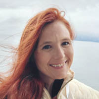 Amanda smiling with the sea behind her