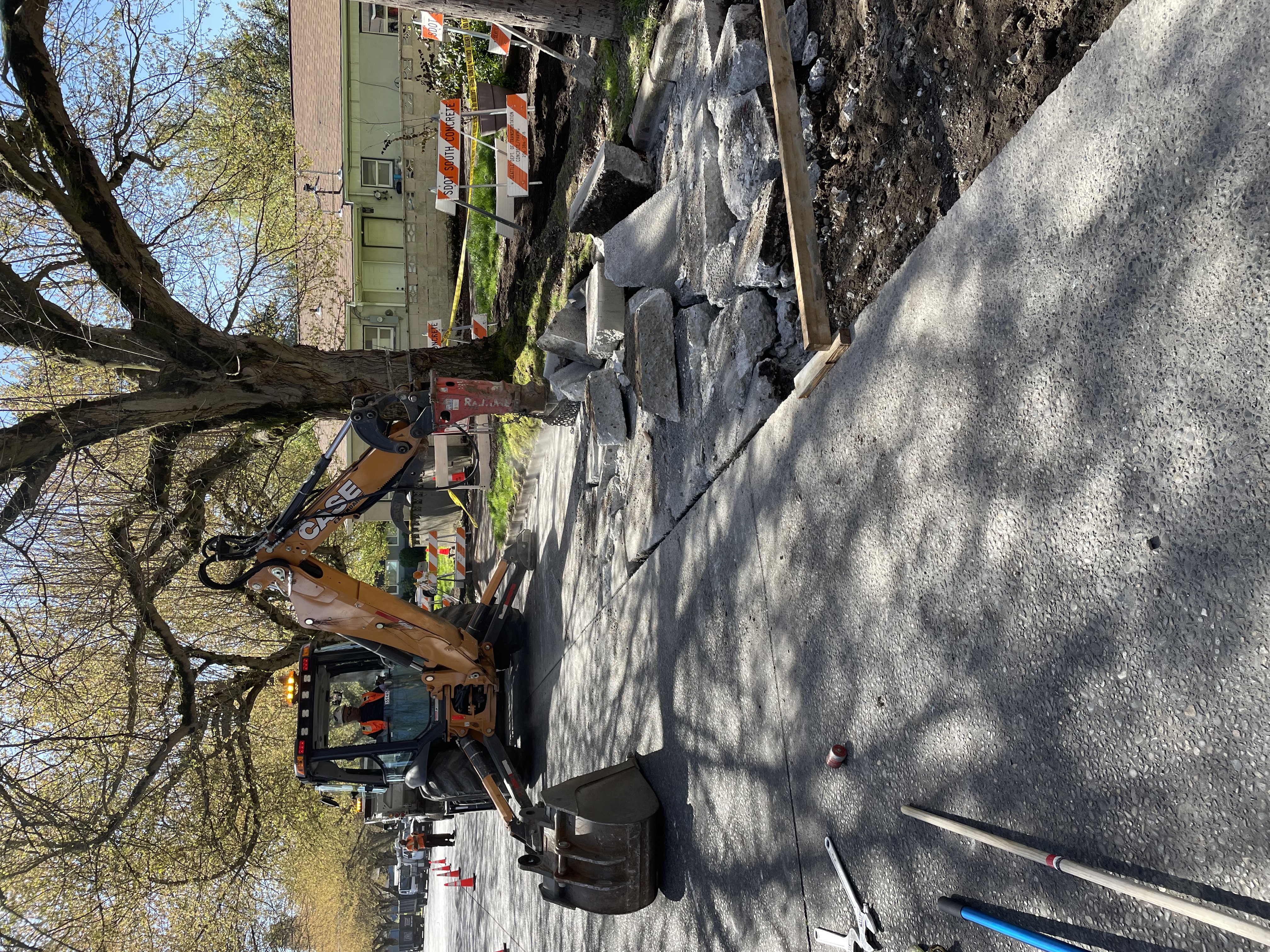 Excavator tearing up existing roadway