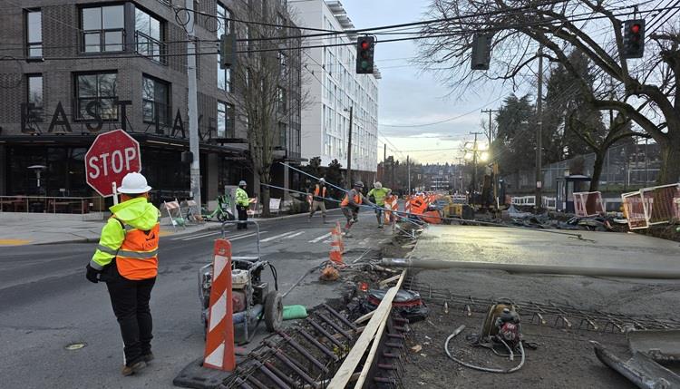 Image shows the team placing new concrete street panels at the intersection of Eastlake Ave E and E Louisa St