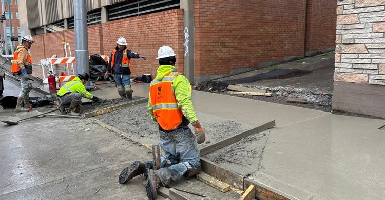 Concrete being poured at the entrance to an alleyway on NE 43rd St