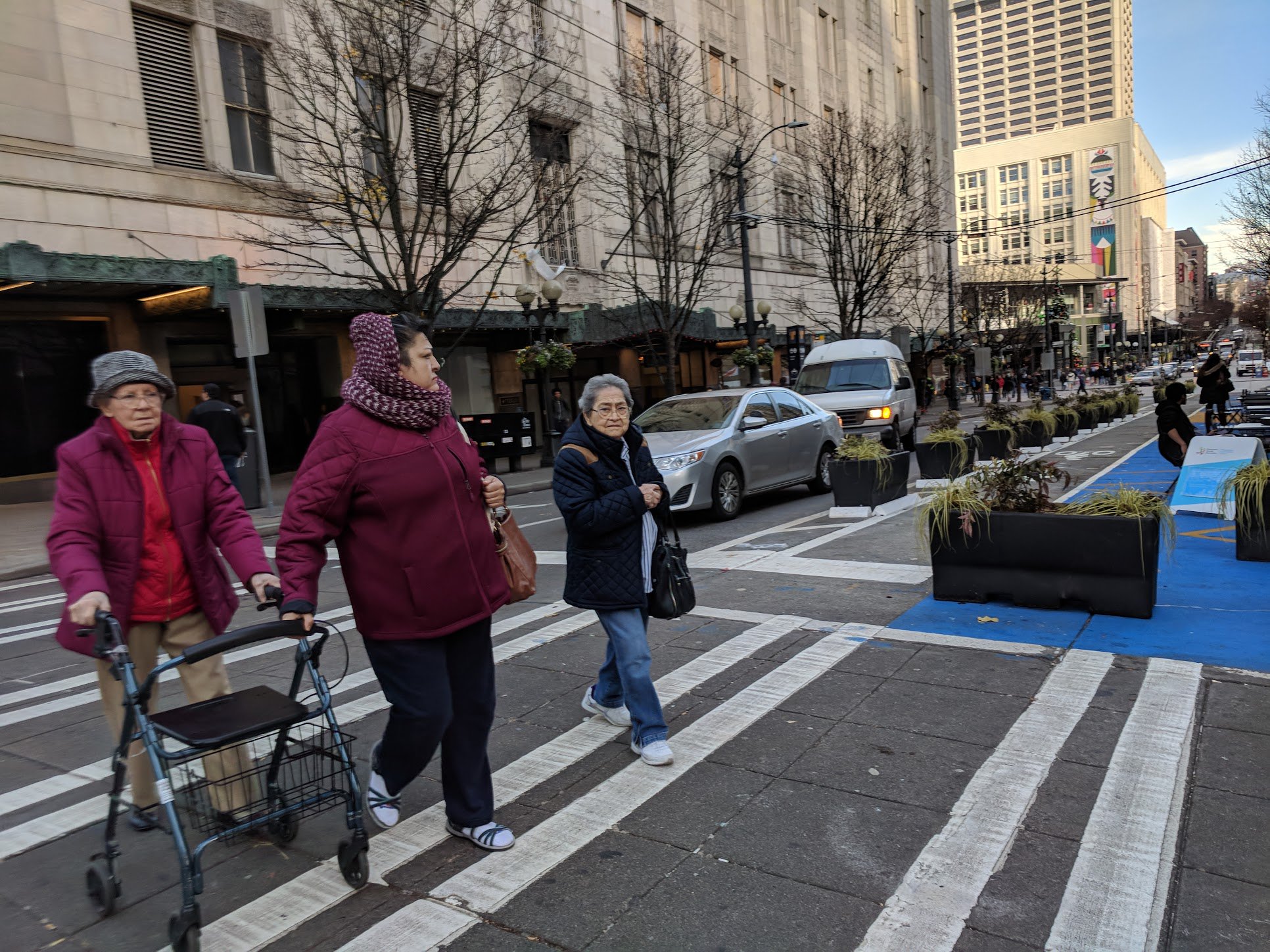 Three seniors cross the street on Pine Street in downtown Seattle.