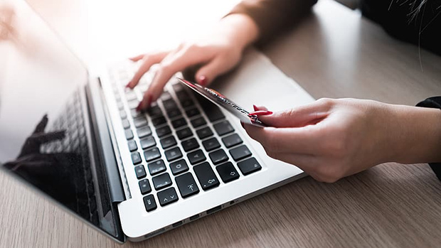 Person paying bill with a laptop and credit card