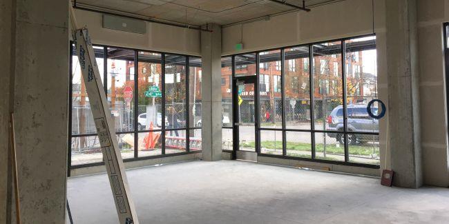 የሲሚንቶ ወለልና መስኮቶች ያለው አንድ አዲስ ህንጻ ውስጥ አንድ ባዶ ክፍል 