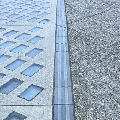 A close up view of a tactile strip along the promenade walkway