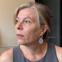 Gülgün has long graying hair pulled back and wears dangly earrings.