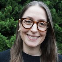 Sarah has long brown hair and thick glasses.