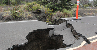 Large cracked hole on the road due to an earthquake.