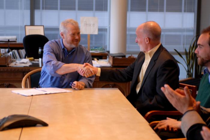Councilmember Burgess and Mayor McGinn shake hands over wage theft legislation