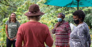 People standing in a circle at an urban farm