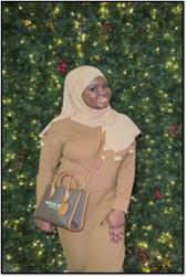 Full body photo of Fatima Kabba smiling in casual attire. 