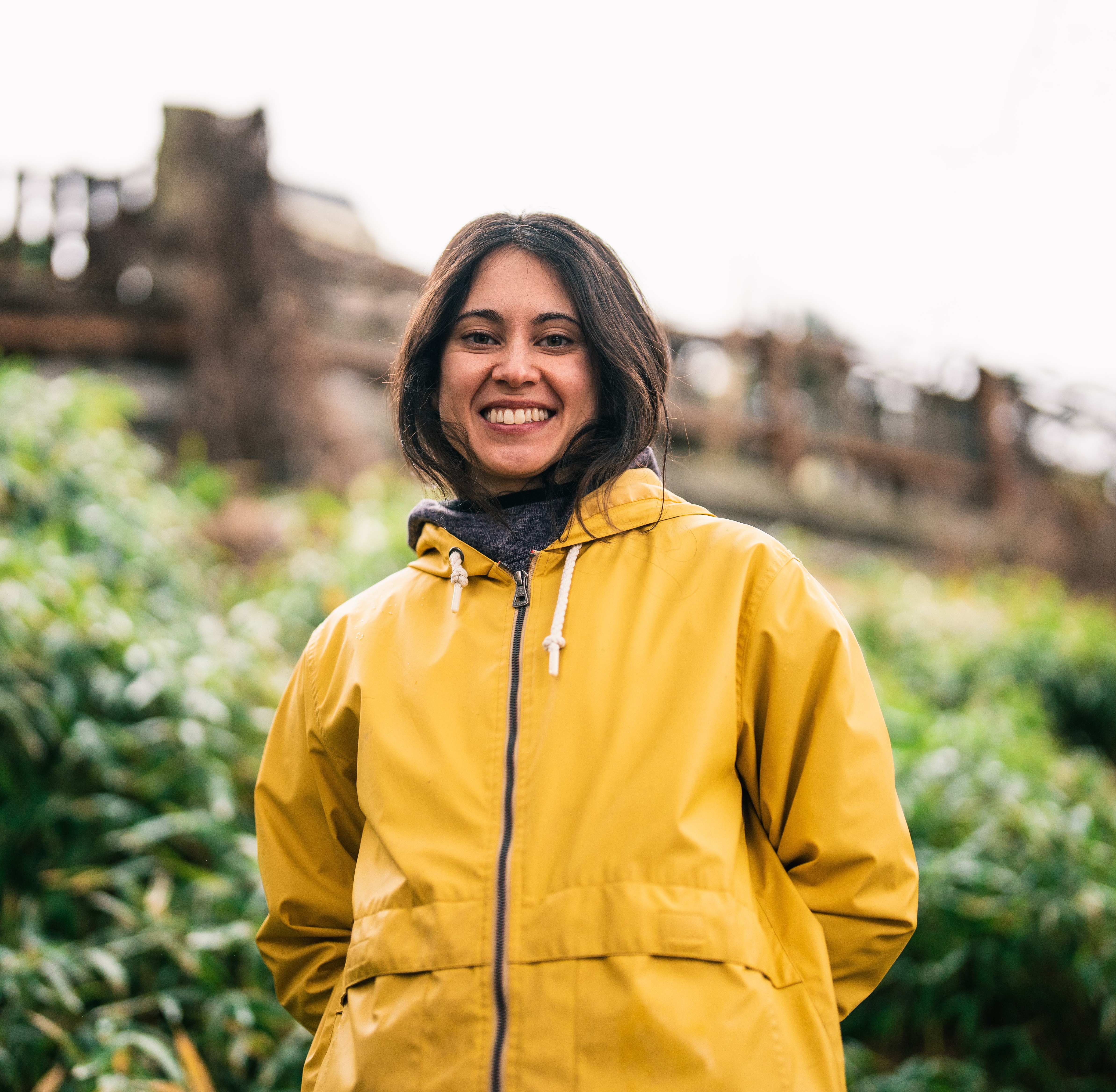 Close up of Elizabeth Baskerville form the midriff up smiling in a yellow rain jacket.  