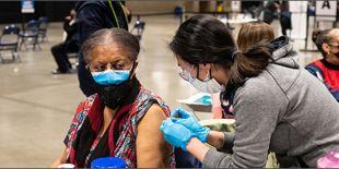 A woman getting vaccinated at a mass vaccination site in Seattle