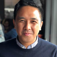 Photo of Jules Posadas smiling near a window