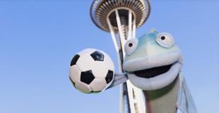 Sal the Salmon with a soccer ball in front of the Space Needle