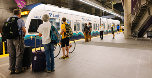People waiting at an underground stop to board link light rail