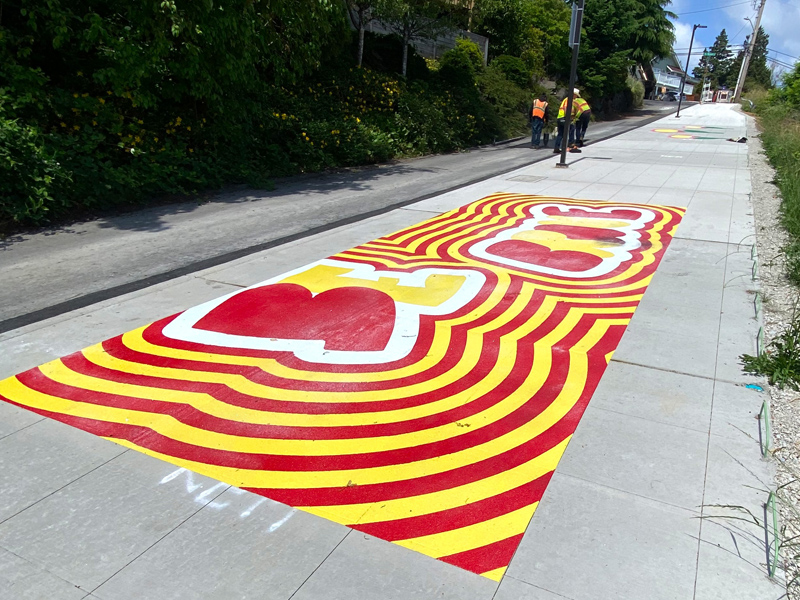 Crew installing red and yellow art, designed by Acila Antonio