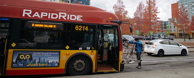 A man loading his bicycle onto the front of a RapidRide bus