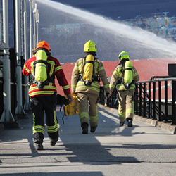 3 firefighters in their full gear walking together